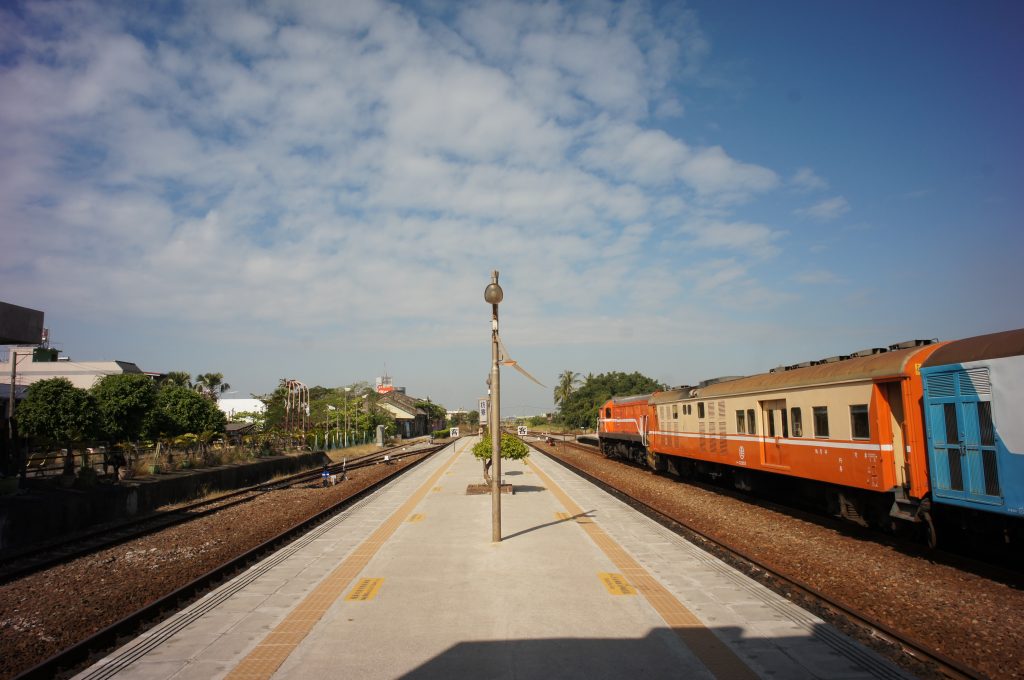 picture showing Platform of Fangliao Station with an orange train on the right.