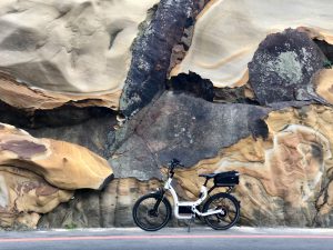 e-bike in front of a big colourful rock